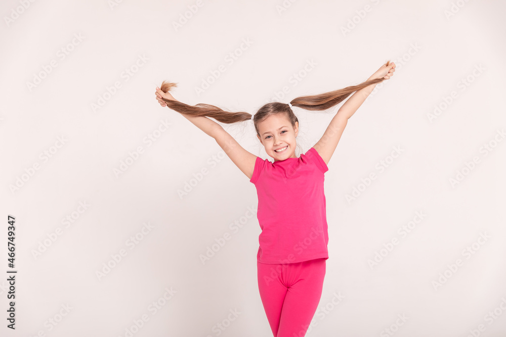 happy child on a white background. a girl in a pink T-shirt and pants. happy child on a white background. a girl in a pink T-shirt and pants.