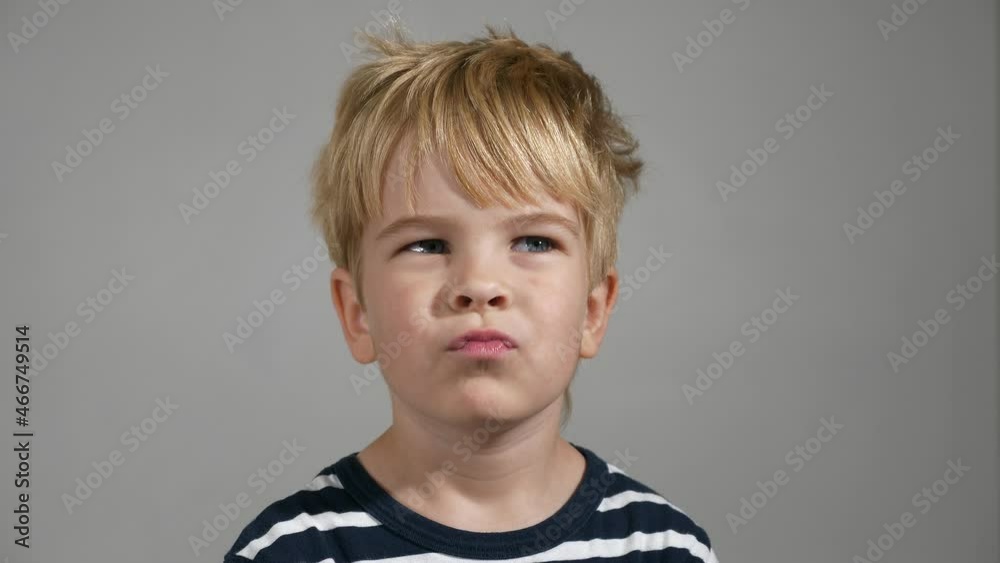 Thoughtful Child Face Emotions. Portrait Cute Little Boy Thinking. Serious Kid against White Wall Background. Slow motion 4K Thoughtful Child Face Emotions. Portrait Cute Little Boy Thinking. Serious Kid against White Wall Background. Slow motion 4K