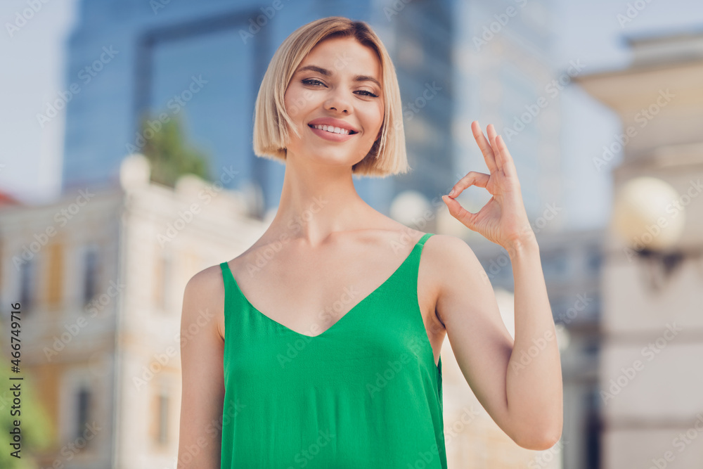 Photo of adorable sweet young lady wear green outfit smiling walking showing okey sign outside urban city street Photo of adorable sweet young lady wear green outfit smiling walking showing okey sign outside urban city street