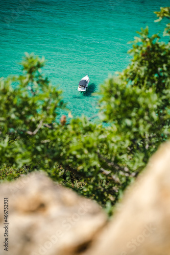 Lonely yacht boat moored in bounty lagoon, Cape Fiolent in Balaklava, Sevastopol, Russia. View from the top of the rock. Azure emerald gree sea water on sunny day. Vacation summer travel concept photo