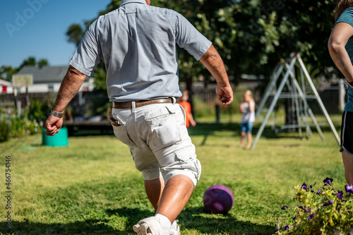 Playing kickball with grandpa in the backyard photo