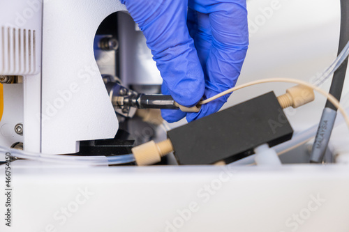 Fotografie Chemist connecting nebulizer to ion source of mass spectrometer