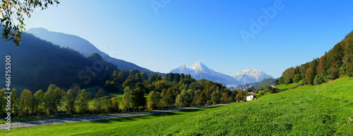 malerischer weiter Panoramablick durch grünes Tal zum Gipfel des Watzmann unter blauem Himmel