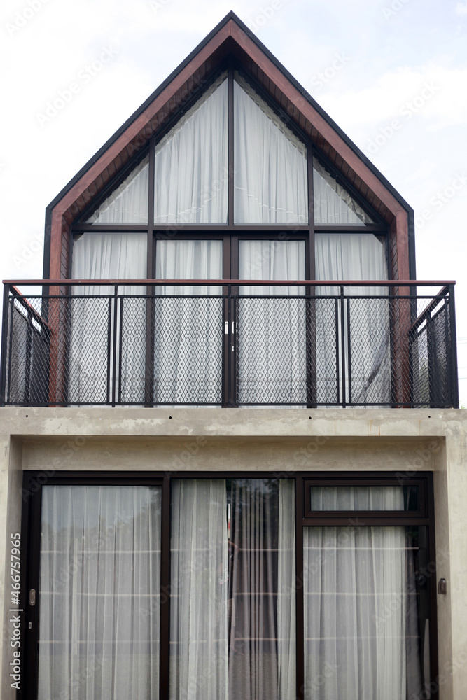 Modern minimalism log house against bright blue sky with white clouds. Copy space