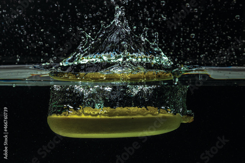 Close up view of banana falling in water on black background. Gorgeous backgrounds.