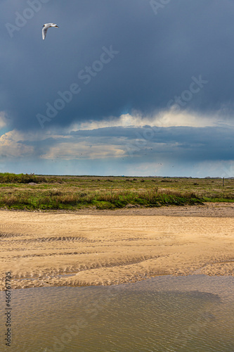 A rain storm approaching the River Glaven on the Blakeney National Nature Reserve at Blakeney, Norfolk UK photo