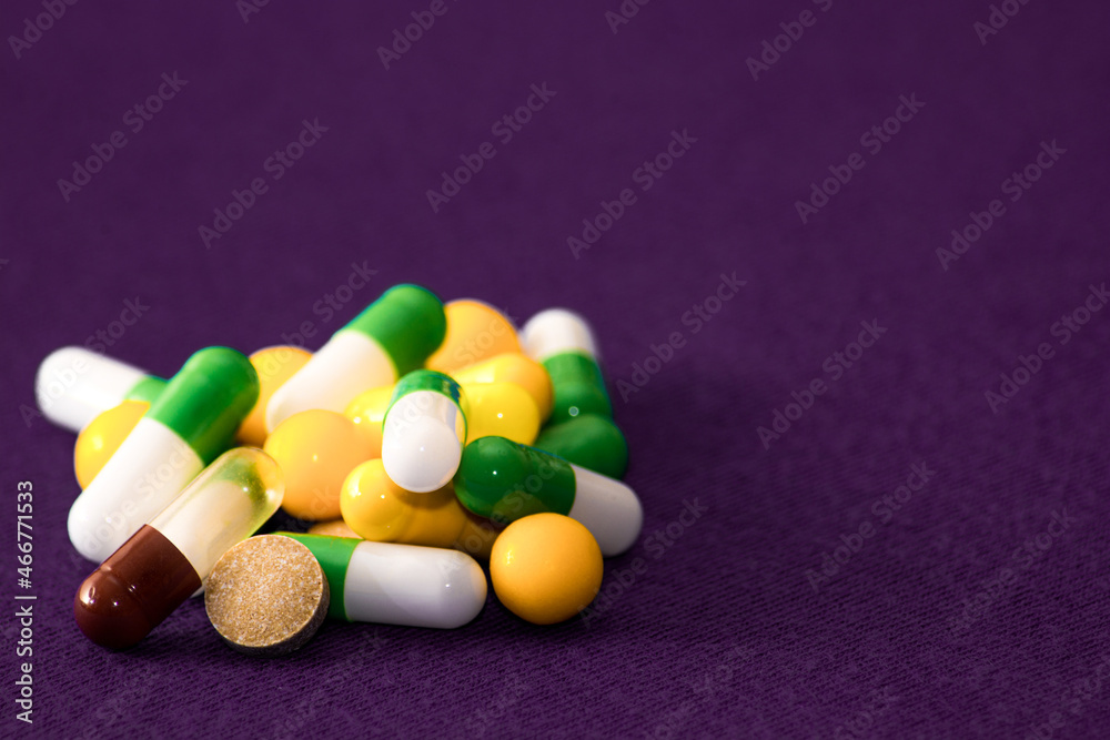 Medical pills. Color capsules medication. Purple background. Health care concept. Free space for text. Medicines. Many different pills. Chemical industry. Medical pills. Color capsules medication. Purple background. Health care concept. Free space for text. Medicines. Many different pills. Chemical industry.