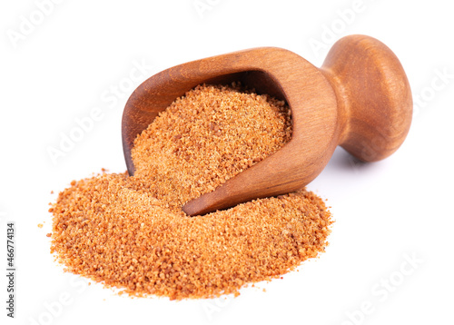 Coconut sugar isolated on white background. Brown unrefined coconut palm sugar in wooden scoop.