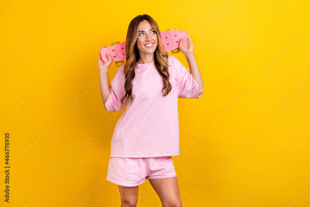 Photo of young woman happy positive smile skater sporty dream look empty space isolated over yellow color background Photo of young woman happy positive smile skater sporty dream look empty space isolated over yellow color background