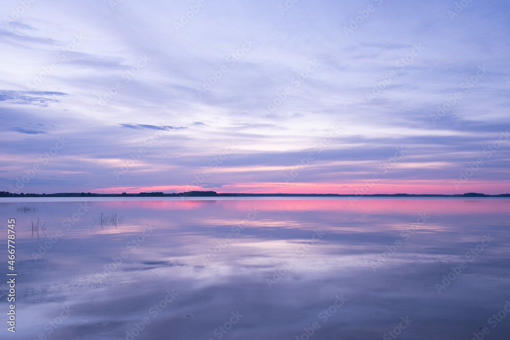 Nice sunset over lake, the sky is reflected in the water, Kostroma, Russia