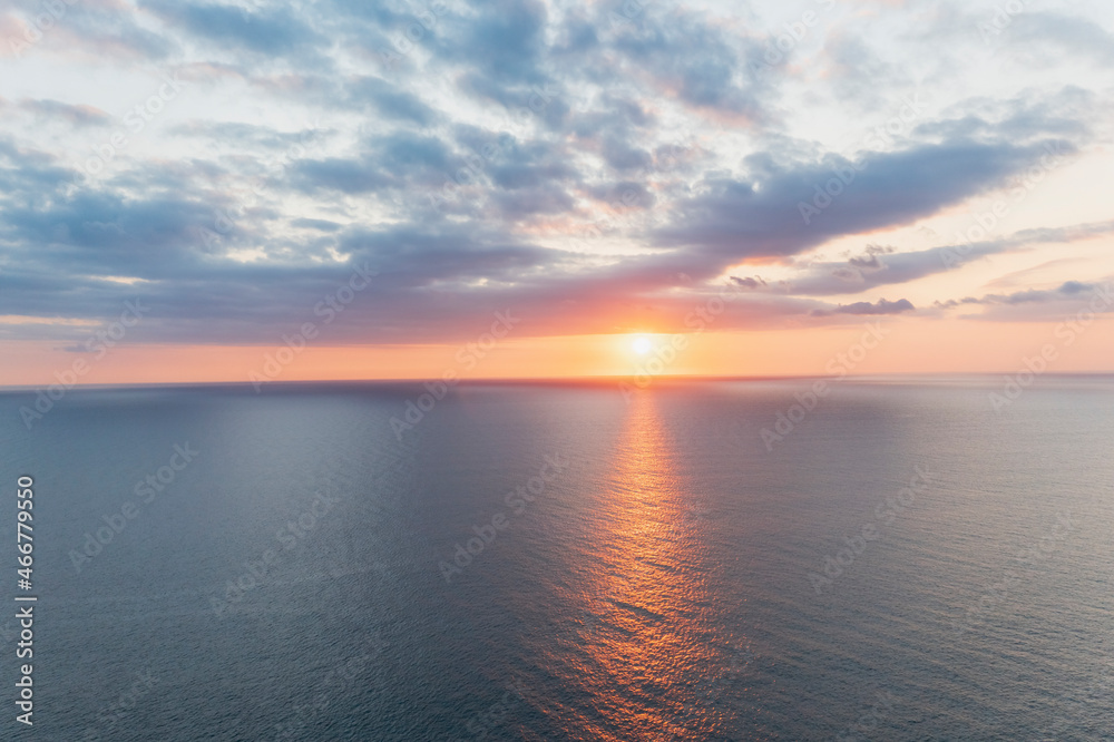 Aerial view of a beautiful sunset with dramatic clouds in sky in the middle of the Atlantic Ocean off Cornwall coastline, England. Aerial view of a beautiful sunset with dramatic clouds in sky in the middle of the Atlantic Ocean off Cornwall coastline, England.