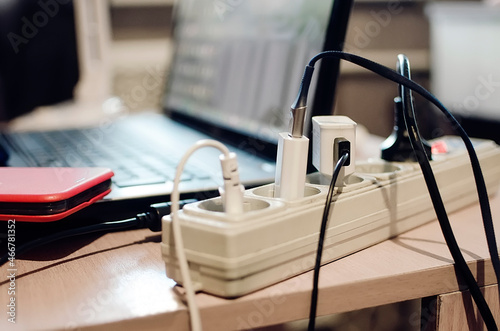 extension socket with various chargers and devices connected. Freelancer workplace at home. photo