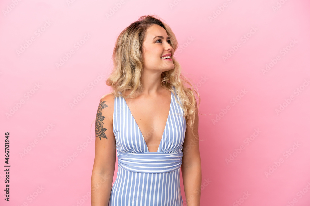 Young Brazilian woman in swimsuit in summer holidays isolated on pink background thinking an idea while looking up Young Brazilian woman in swimsuit in summer holidays isolated on pink background thinking an idea while looking up