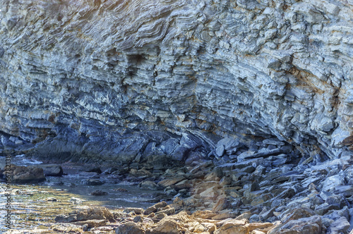 Detail of a rock with variants of blue. Rock full of curves and smooth cuts resulting from the erosive effect of sea.Stones texture and background. Rock texture.Stone