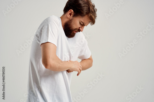 man in white t-shirt joint pain hand health problems