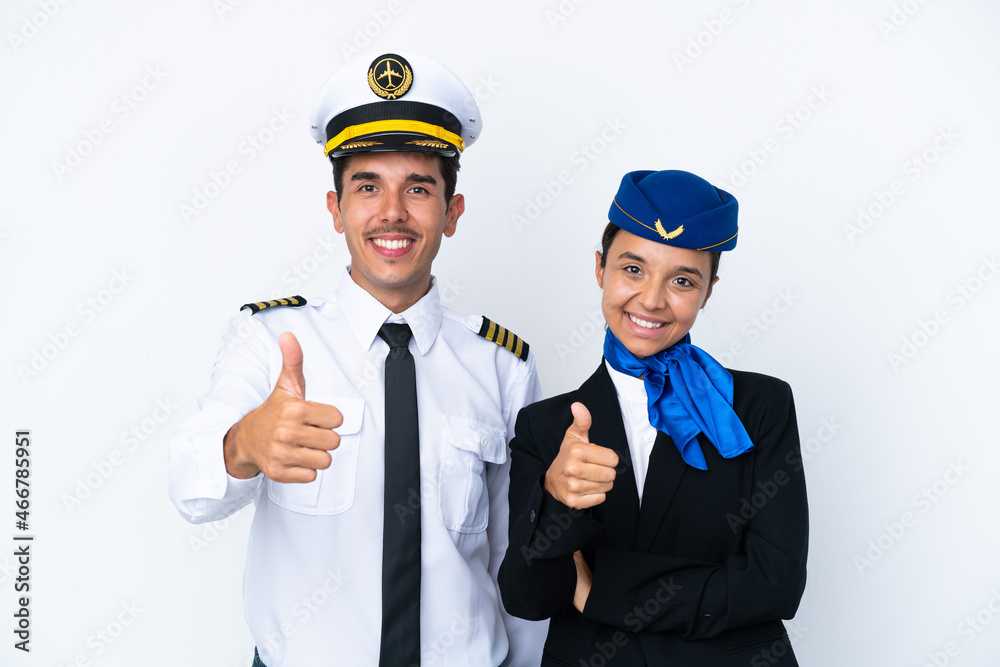 Airplane pilot and mixed race air hostess isolated on white background giving a thumbs up gesture because something good has happened Airplane pilot and mixed race air hostess isolated on white background giving a thumbs up gesture because something good has happened