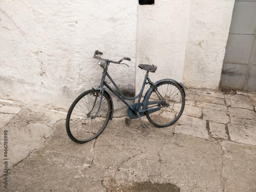 Altes blaues Retro Fahrrad an der weißen Hauswand
