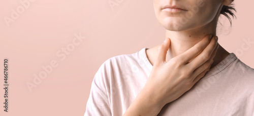 Sore throat. Close-up of young woman hand touching her neck. Healthcare and medical concept. Banner concept, copyspace for your text. 