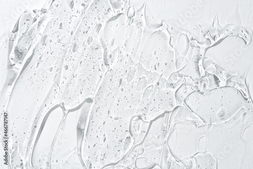 Cosmetic gel or beauty jelly serum texture background. Transparent skin care collagen product backdrop. Antibacterial sanitizer or liquid water moisture toner smudged smear close up photo