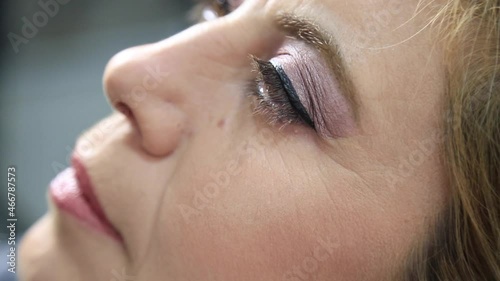 Process of making makeup. Make-up artist working with brush on model face. Portrait of young brunette woman in beauty saloon interior. Applying tone to skin.