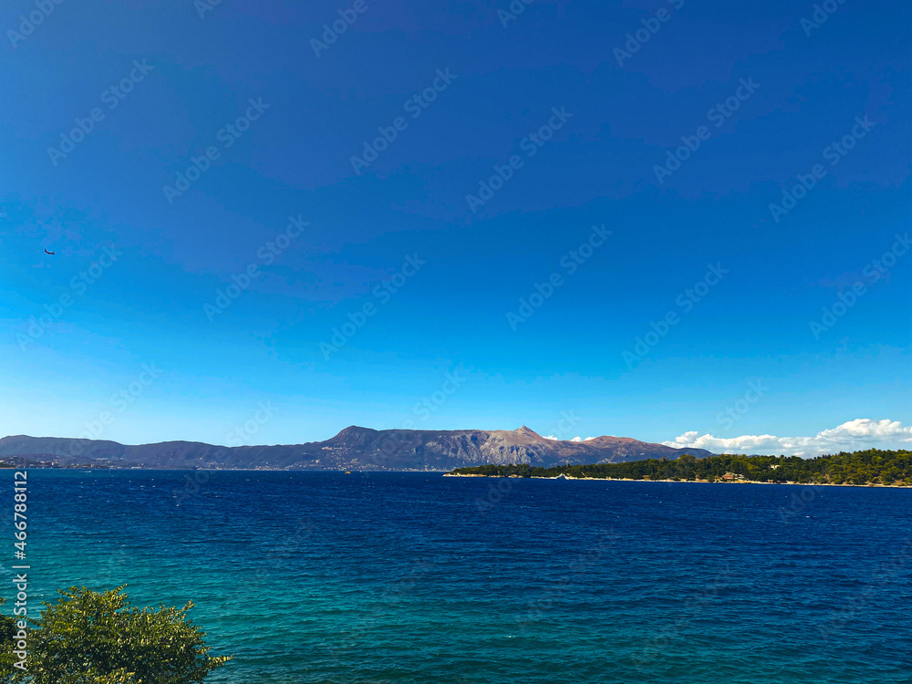Paysage de mer bleue avec montagne et île en fond , ciel bleu