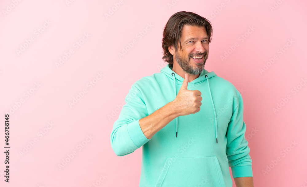 Senior dutch man isolated on pink background giving a thumbs up gesture Senior dutch man isolated on pink background giving a thumbs up gesture