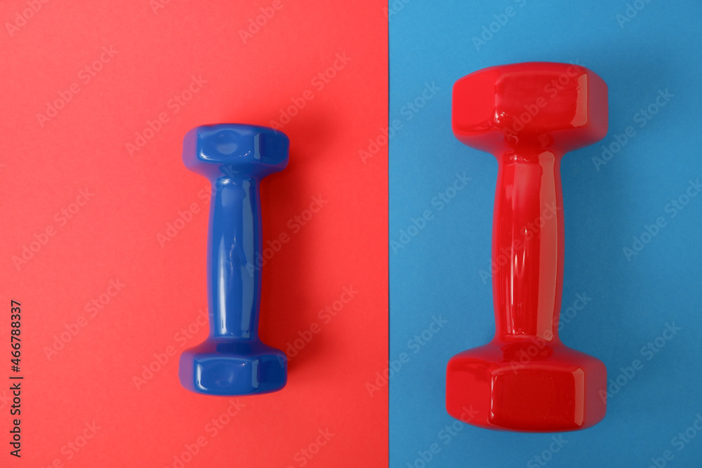 Red and blue dumbbells on an inverted background. Sport and fitness equipment, dumbbells Red and blue dumbbells on an inverted background. Sport and fitness equipment, dumbbells
