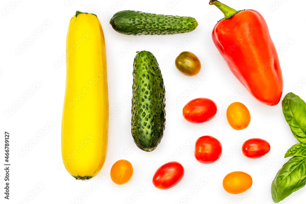 Vegetable flatlet: cucumbers, zucchini, cherry tomatoes, a sprig of basil and peppers on a white plate. Vegetable flatlet: cucumbers, zucchini, cherry tomatoes, a sprig of basil and peppers on a white plate.