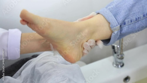 Young woman getting professional pedicure in beauty salon
