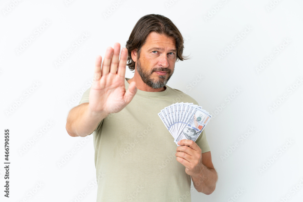 Senior dutch man taking a lot of money isolated on white background making stop gesture Senior dutch man taking a lot of money isolated on white background making stop gesture