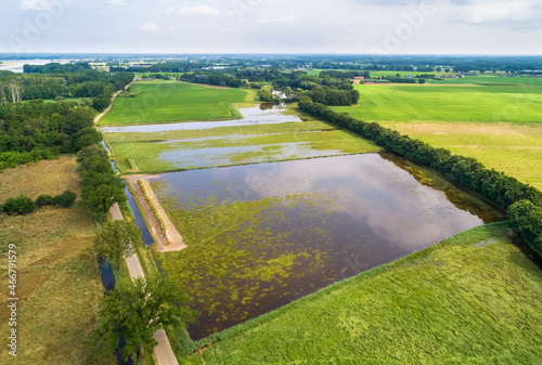Aerial view of flooded farmland next to climate buffer Ooijen-Wanssum during a high water period in river Maas in summer, Swolgen, Limburg, Netherlands. photo