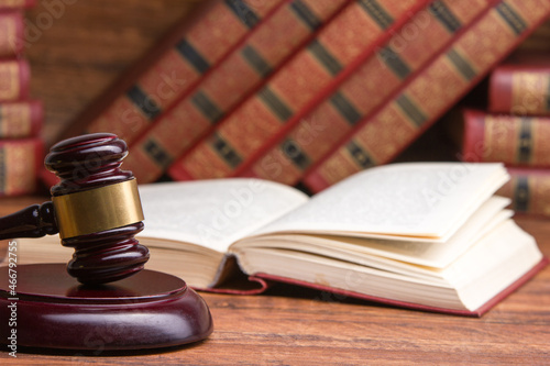 Law concept - Open law book with a wooden judges gavel on table in a courtroom or law enforcement office isolated on white background. Copy space for text.