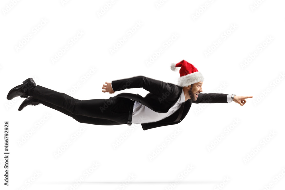 Full length shot of a businessman with a christmas santa hat flying and pointing