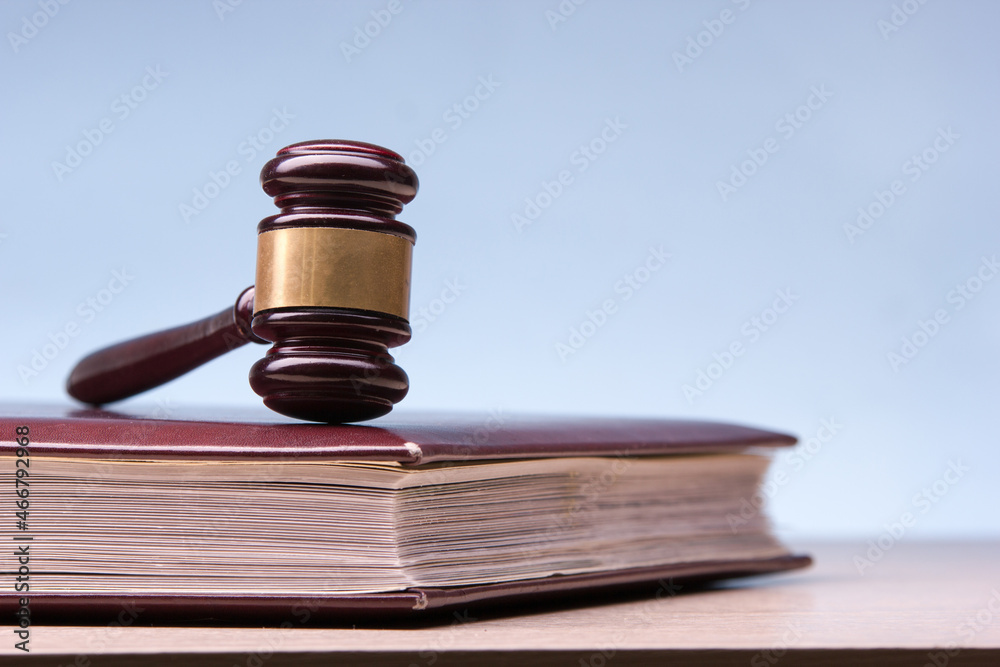 Law concept - Open law book with a wooden judges gavel on table in a courtroom or law enforcement office isolated on white background. Copy space for text. Law concept - Open law book with a wooden judges gavel on table in a courtroom or law enforcement office isolated on white background. Copy space for text.