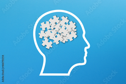 Confusion concept, mental health and problems with memory. Human brain shaped made of white jigsaw puzzles inside your head