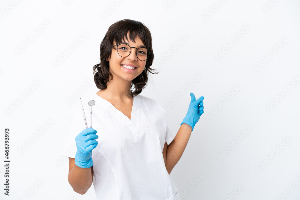 Young woman holding tools isolated on white background pointing back Young woman holding tools isolated on white background pointing back