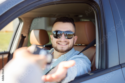 Businessman getting his new car key in his car.