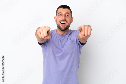 Young handsome caucasian man isolated on white background surprised and pointing front