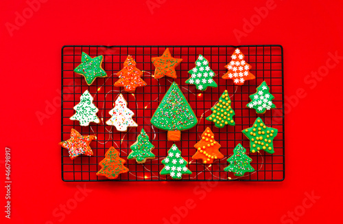 Bright festive Christmas tree cookies prepared at home. on a red background. Beautiful Background of their bright Christmas and New Year homemade cookies.