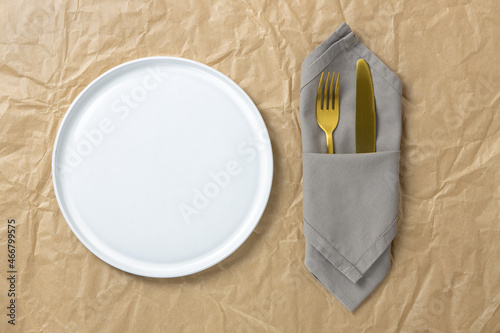 Wallpaper Mural Cutlery, gold fork and knife in folded cloth napkin near white round empty plate on crumpled craft paper, mock up, flat lay, copy space. Table setting concept, environmentally friendly, zero waste Torontodigital.ca