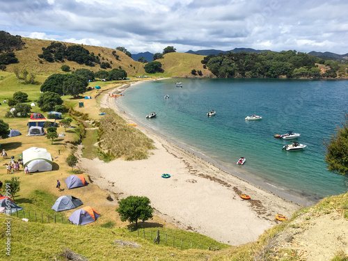 Photography View of campsite on Urupukapuka Island, boats in the bay, golden sand, summer fe