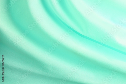 turquoise material flows in soft folds background