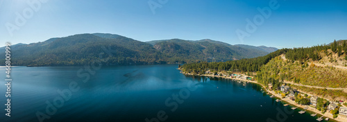 Aerial panoramic view of a residential homes by a lake and mountains. Christina Lake, East Kootenay, British Columbia, Canada. photo