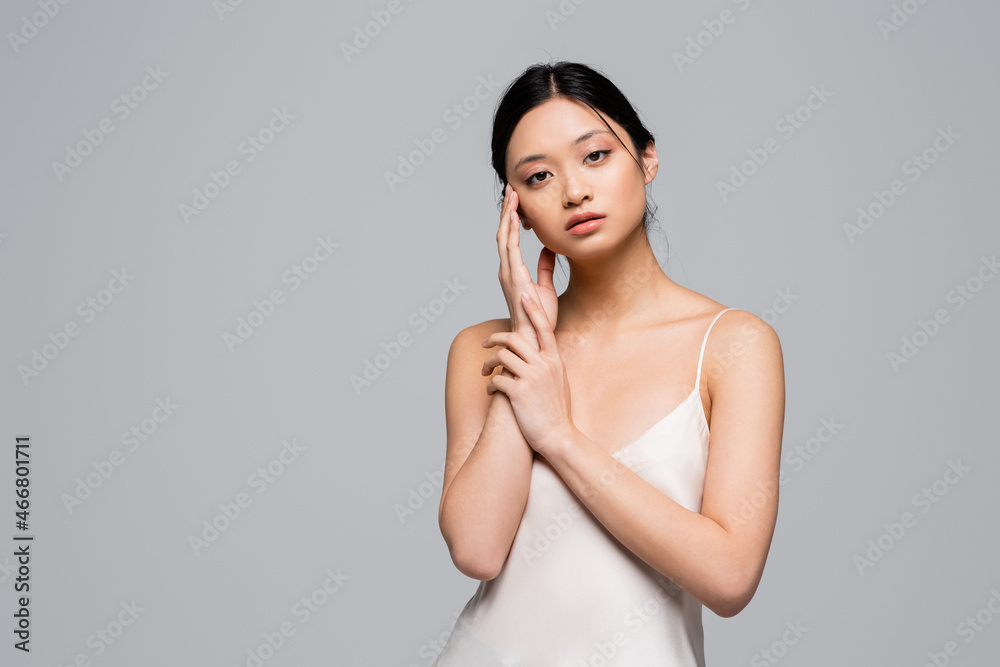 Pretty asian woman in satin dress looking at camera isolated on grey Pretty asian woman in satin dress looking at camera isolated on grey