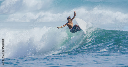 Young man surfer surfing tropical ocean wave riding barrel tube