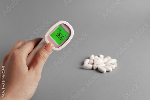 electronic thermometer with a green screen on a gray background, temperature 36.6