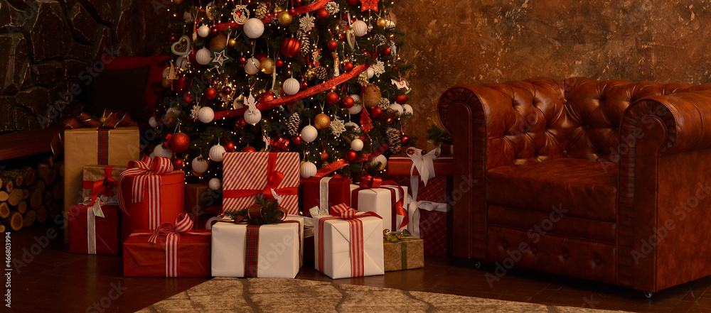 Christmas, New Year's interior. Beautifully luxury decorated Christmas tree, boxes with gifts,leather brown armchair, firewood on the background of a brown modern wall and a stone gray wall.