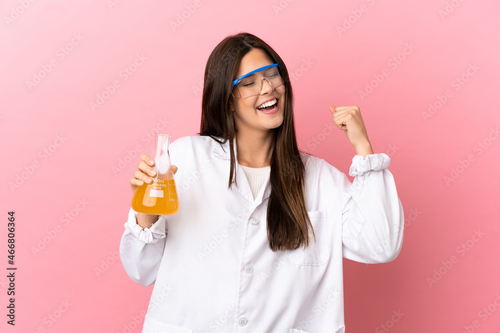 Young scientific girl over isolated pink background celebrating a victory Young scientific girl over isolated pink background celebrating a victory