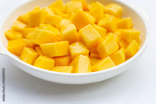 Tropical fruit, Mango cube slices in white bowl on white background.