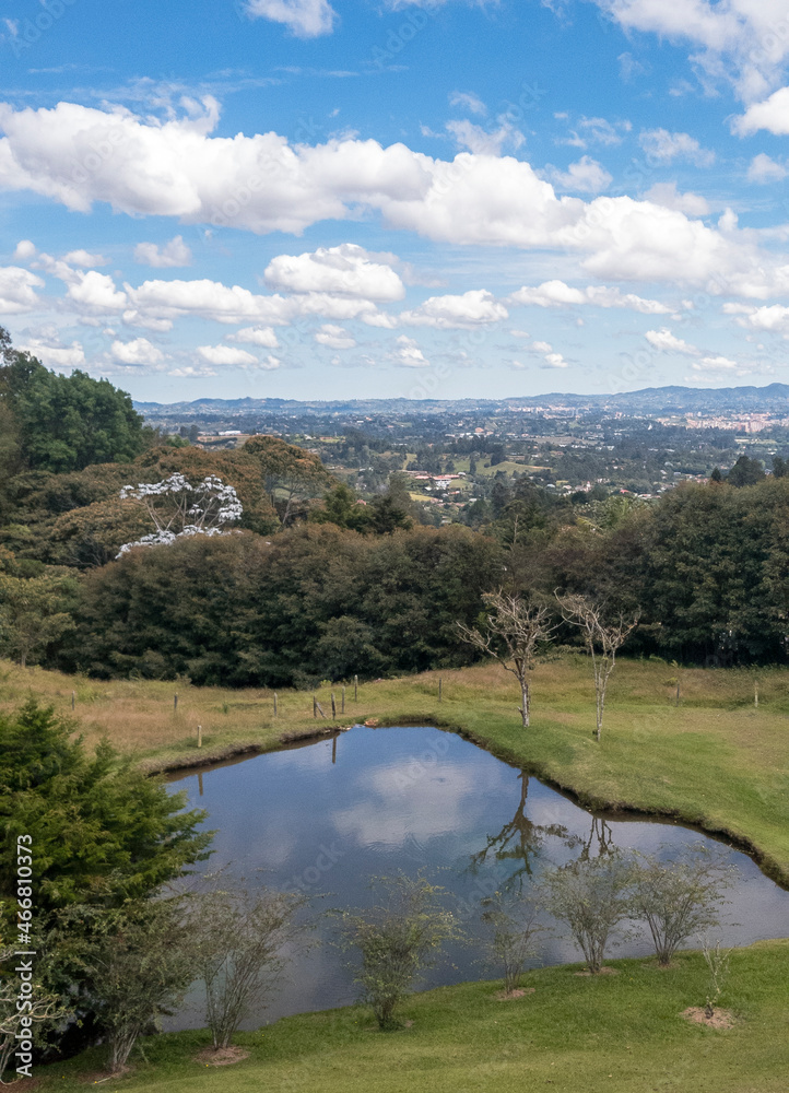Panoramic landscape with lake and reflection of the sky in the water. Llano Grande, Antioquia, Colombia.